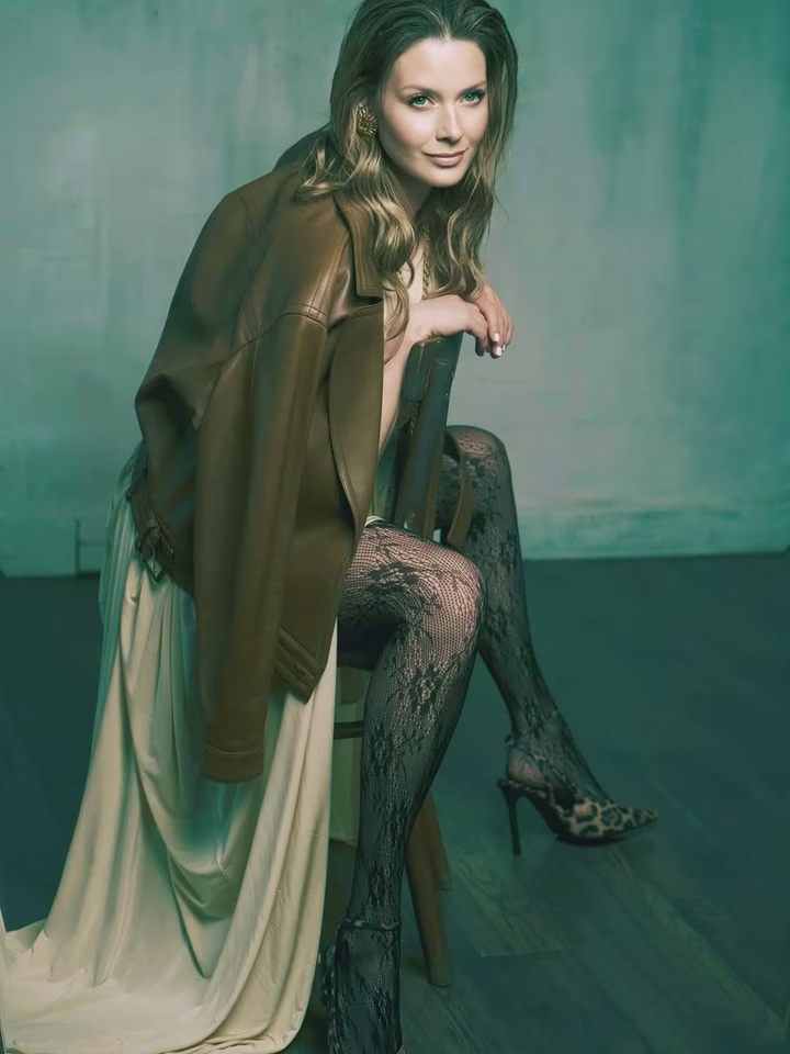 Любава Грешнова у сексі сукні посвітила ногами на стільці у студії