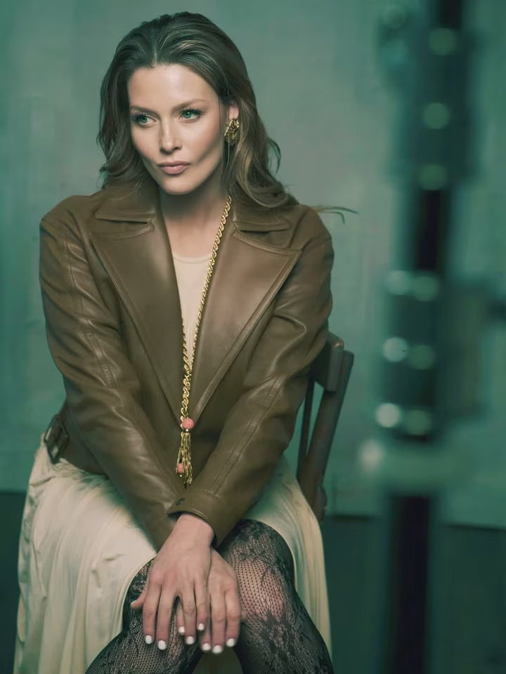 Любава Грешнова у сукні та шкірянці попозувала на стільці для фото