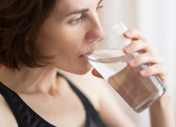 Дівчина займається спортом, напої перед тренуванням