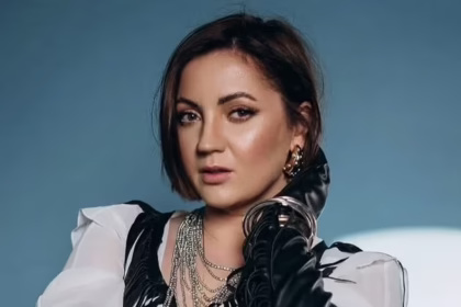 Оля Цибульська в чорній максісукні з декольте на комоді